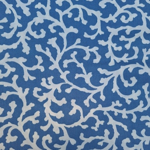 Puede incluir: Tela azul con un patrón floral blanco. El patrón se asemeja a ramas y hojas.