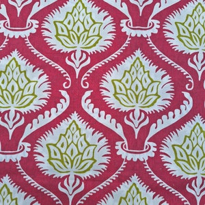 Op de afbeelding: Een roze stof met een wit en groen bloemenpatroon. Het patroon is een herhalend ontwerp van gestileerde bloemen met een centrale knop en bladeren.