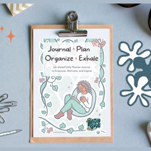 May include: A light blue and green journal cover with a woman sitting in a leafy vine with a book and a cup. The text on the cover reads "Journal + Plan Organize + Exhale Un-dated Daily Planner-Journal to Empower, Motivate, and Inspire". The bottom of the cover has a logo that reads "ARTIZEN SOUL".