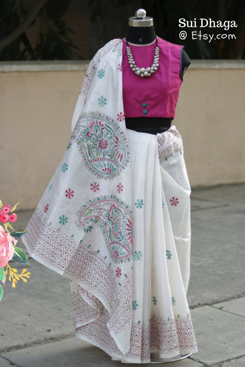 Puede incluir: Un sari blanco con un dise&ntilde;o de cachemira y floral en verde azulado, rosa y verde. Se combina con una blusa magenta y un collar de cuentas plateadas. El texto "Sui Dhaga @ Etsy.com" es visible.