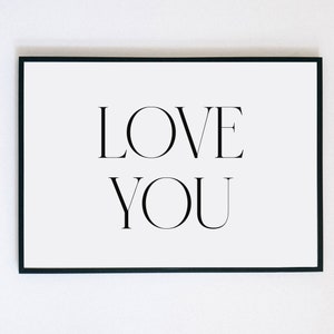 May include: A black framed print with the text "LOVE YOU" in white.