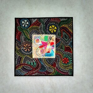 May include: A colorful, abstract quilt with a black background. The quilt is made of various fabrics and materials, including beads and sequins. The quilt features a central square with a colorful, abstract design.
