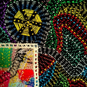 May include: A close-up of a colorful quilt with a variety of stitches and patterns. The quilt is made of different fabrics and colors, including red, green, blue, yellow, and white. The quilt is stitched together with a variety of stitches, including straight stitches, zig-zag stitches, and cross-stitches.