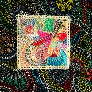 May include: A colorful, abstract embroidery design with a square frame. The embroidery is done in a variety of colors, including red, blue, green, yellow, and white. The design is intricate and detailed, and it is a beautiful example of hand-stitched art.