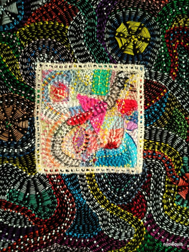 May include: A colorful, abstract embroidery design with a square frame. The embroidery is done in a variety of colors, including red, blue, green, yellow, and white. The design is intricate and detailed, and it is a beautiful example of hand-stitched art.