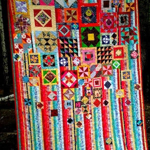 Könnte beinhalten: Ein farbenfroher Quilt mit einer Vielzahl von Patchwork-Quadraten und Streifen in Rot, Gelb, Blau, Grün und Weiß. Der Quilt besteht aus vielen verschiedenen Mustern und Designs.