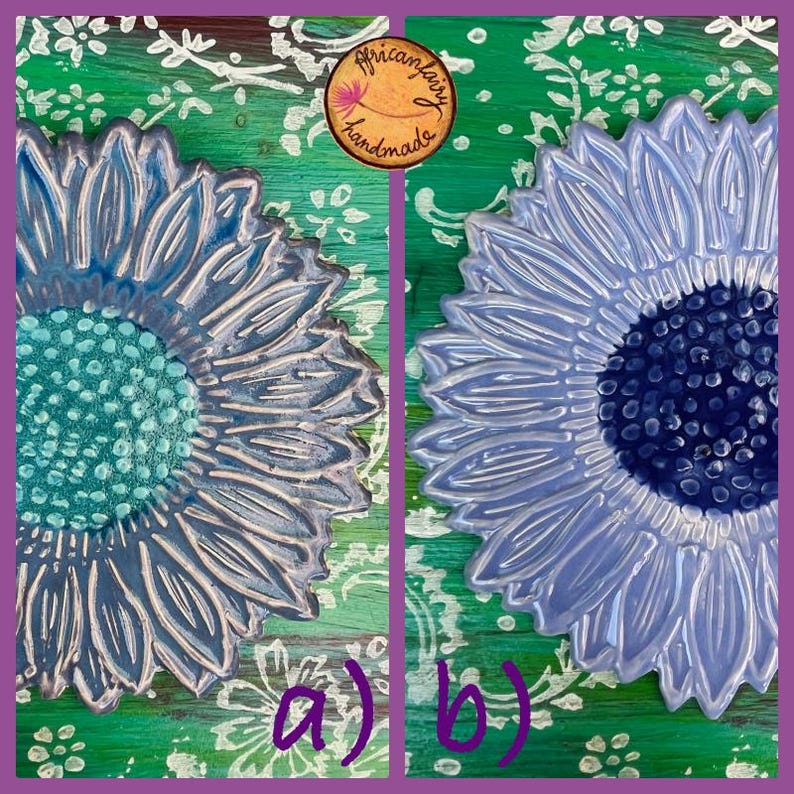 May include: Two ceramic sunflower designs, one with a teal center and the other with a dark blue center, are displayed side-by-side. The petals are a light blue-gray color. The background is green with white floral patterns. The image includes the text "a)" and "b)".