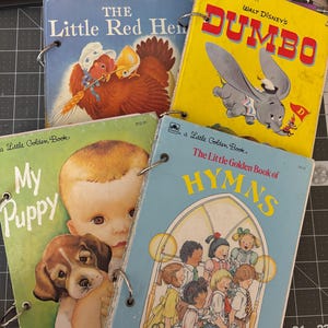 May include: A collection of vintage "Little Golden Books" featuring titles like "The Little Red Hen," "Dumbo," "My Puppy," and "The Little Golden Book of Hymns." The books are bound with metal rings and showcase colorful illustrations.