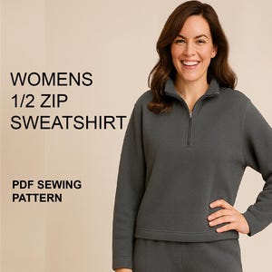 May include: A dark gray 1/2 zip sweatshirt. The sweatshirt has a zipper that goes down the chest. The text "WOMENS 1/2 ZIP SWEATSHIRT" is on the left side of the image. The text "PDF SEWING PATTERN" is below the sweatshirt text.