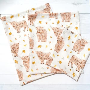 Large, medium and small reusable fabric gift bags with a Highland cow fabric of an autumn theme