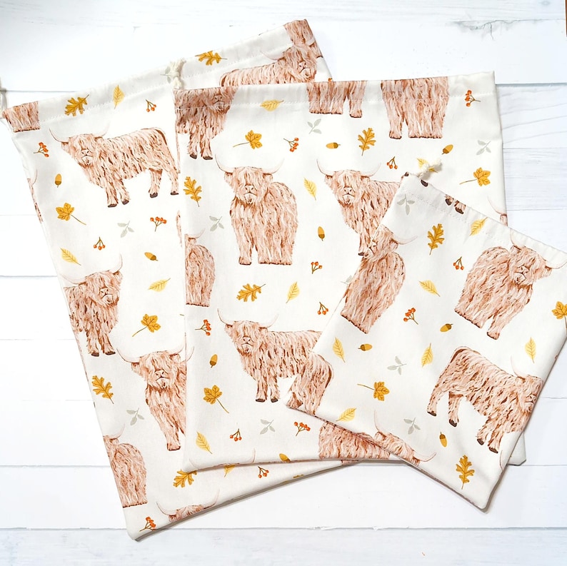 Large, medium and small reusable fabric gift bags with a Highland cow fabric of an autumn theme