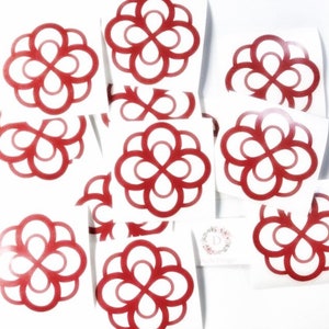 May include: A selection of red vinyl stickers with a floral design. The stickers are on a white background, with multiple examples of the same repeating pattern. A small card with a floral logo is also visible.