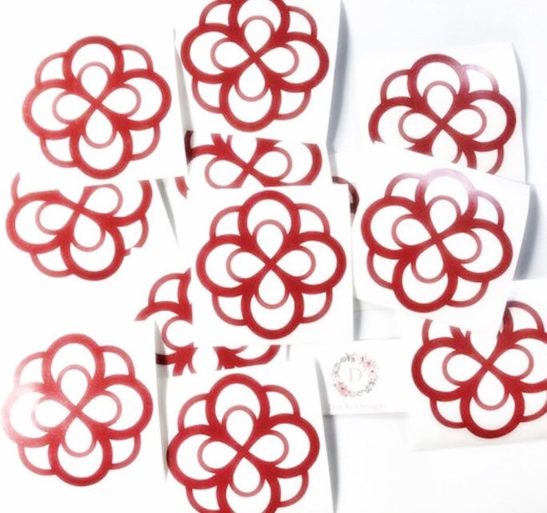 May include: A selection of red vinyl stickers with a floral design. The stickers are on a white background, with multiple examples of the same repeating pattern. A small card with a floral logo is also visible.