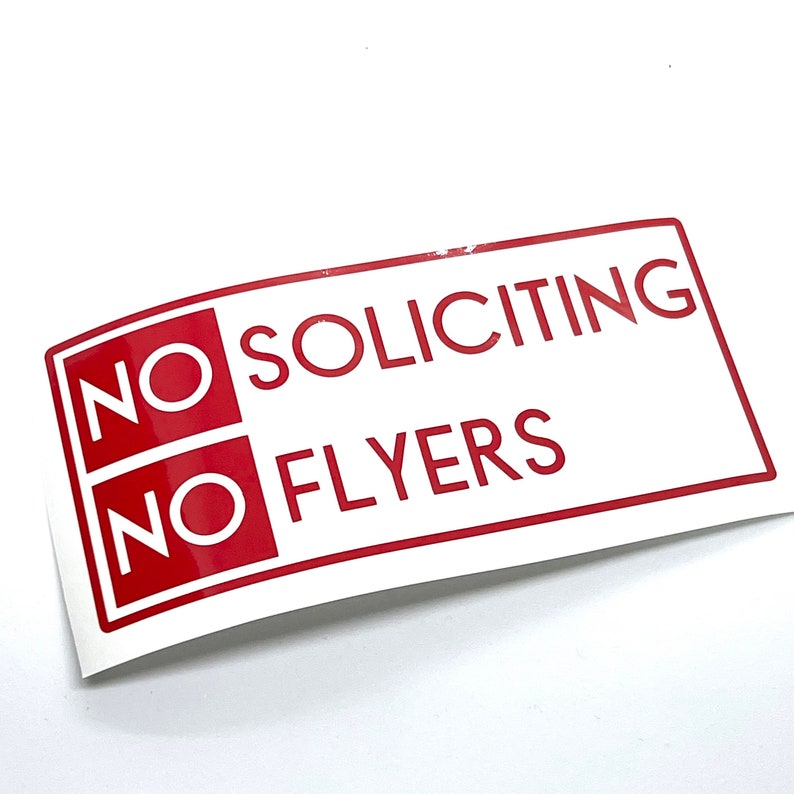May include: White sign with red text that says "NO SOLICITING NO FLYERS".