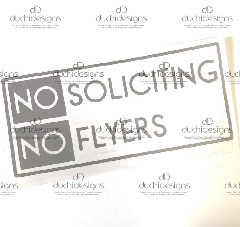 May include: A white sign with black text that reads "NO SOLICITING NO FLYERS".
