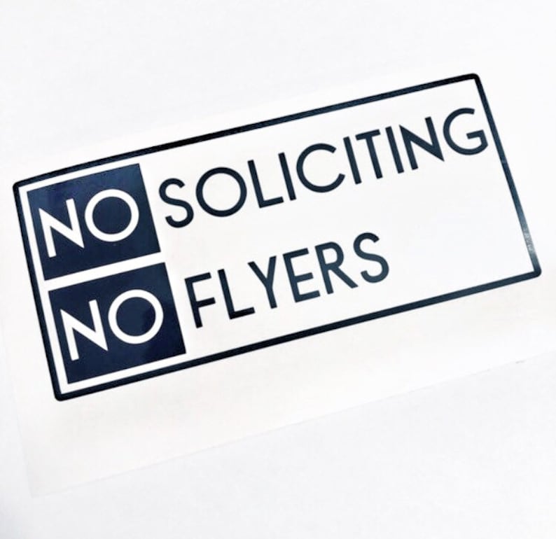 May include: Black and white sign with the text "NO SOLICITING NO FLYERS" in a bold, sans-serif font.