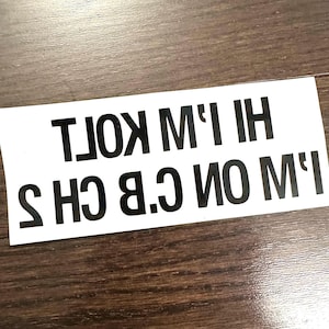 May include: White sticker with black text that reads "I'm on C.B. 2  HI I'M KOLT"