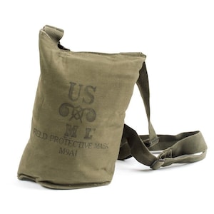 May include: An olive green canvas Field Protective Mask M9A1 bag with a shoulder strap. The bag has the text "US", a symbol, and "M L" printed on the front. The words "FIELD PROTECTIVE MASK" and "M9A1" are also printed on the bag.