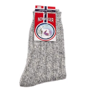 May include: A pair of grey and white marled knit socks with a ribbed texture. A rectangular product tag is attached to the top, featuring a red, white, and blue flag design, the text "NORWEGER", and an illustration of a lamb in a circular frame.