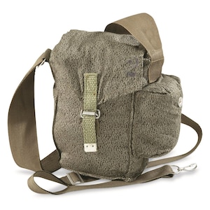 May include: A green canvas shoulder bag with a flap closure and a buckle. The bag has a small pocket on the side and a long adjustable strap.