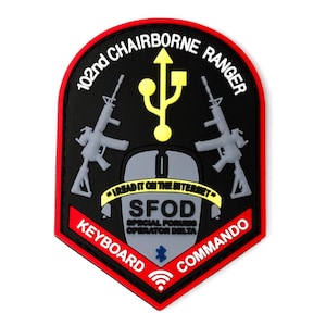 May include: A black and red patch with the text "102nd CHAIRBORNE RANGER" and "KEYBOARD COMMANDO". The patch features a yellow USB symbol, two gray rifles, and a computer mouse. The text "I READ IT ON THE INTERNET" is also present.