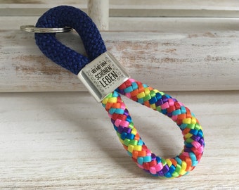 Schlüsselanhänger aus Segelseil mit versilbertem Zwischenstück mit Gravur "Her mit dem schönen Leben", blau/ regenbogen-mix