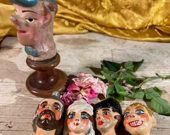 Five heads for puppets or marionettes, one of which is on a pedestal