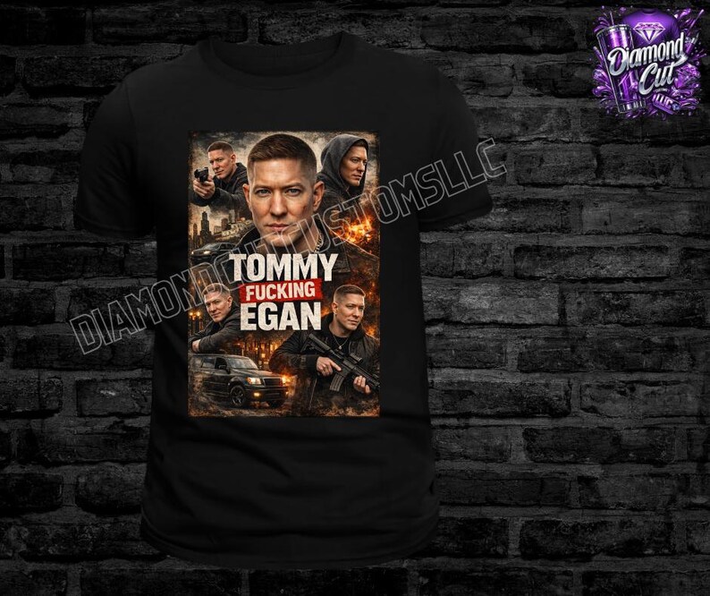 May include: Black t-shirt featuring a graphic of a man with the text "Tommy Fucking Egan". The graphic includes images of the man in various poses. The shirt is displayed against a dark brick wall.
