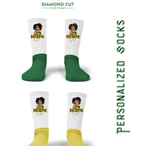 Puede incluir: Cuatro pares de calcetines blancos con un esquema de color verde y amarillo. Cada calcetín presenta un gráfico de una mujer que lleva una camiseta verde y amarilla con el texto "Packers Girl".
