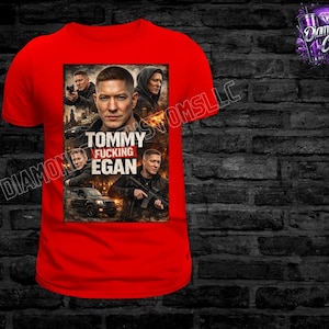 May include: A red t-shirt featuring a graphic of a man with the text "Tommy Fucking Egan". The graphic includes images of the man and other people, with a car and city skyline in the background. The shirt has a crew neck.