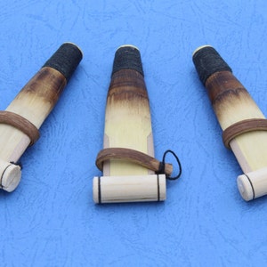 Puede incluir: Tres flautas kaval de madera con detalles en negro y marrón. Las flautas están hechas de madera natural y tienen un diseño sencillo.