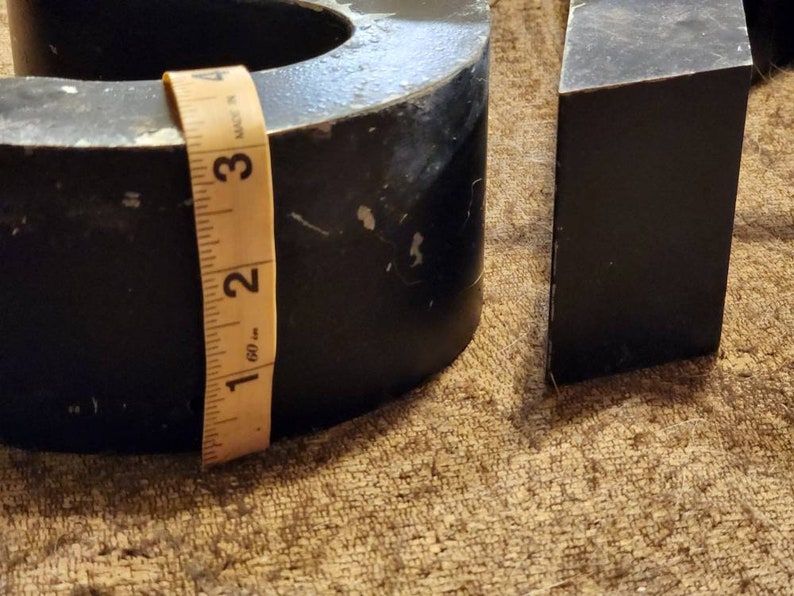 Puede incluir: Un n&uacute;mero nueve de metal negro con una cinta m&eacute;trica amarilla envuelta alrededor. El n&uacute;mero mide aproximadamente 7,6 cm de alto.