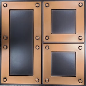 May include: A copper-colored metal wall tile with three rectangular recesses. The recesses have a dark gray finish and are surrounded by a raised copper-colored border.