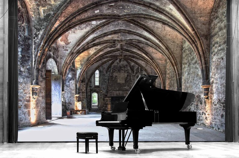 May include: A black grand piano sits in a large, vaulted room with stone walls and arches. The room is empty except for the piano and a black piano stool.