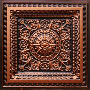 May include: A copper ceiling tile with a black background and an intricate floral design. The tile has a raised, embossed pattern and a polished finish.