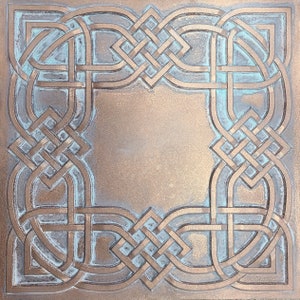 May include: A square, copper-coloured metal plaque with a Celtic knot design in a lighter shade of copper. The knot design is intricate and creates a frame around the centre of the plaque.