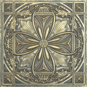 May include: A decorative tile with a gold and black design. The tile features a central flower with four petals and a geometric pattern around the edges.
