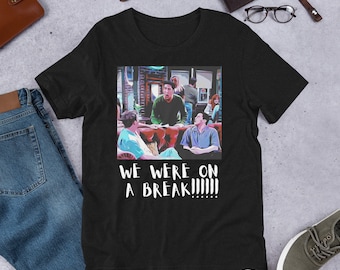 May include: Black t-shirt with a graphic of a scene from the TV show Friends. The graphic shows the characters Ross, Rachel, Monica, Chandler, Phoebe, and Joey. The text "WE WERE ON A BREAK!!!!!" is printed below the graphic.