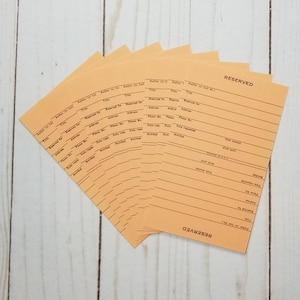 May include: A stack of orange index cards with the word "RESERVED" printed in brown at the top. Each card has lines for writing information, including "Author for Call", "Title", "Reserved for", "Address", "Phone No.", "Date received", "Date req'd", "Date mailed", "Date notified", and "Date notified".
