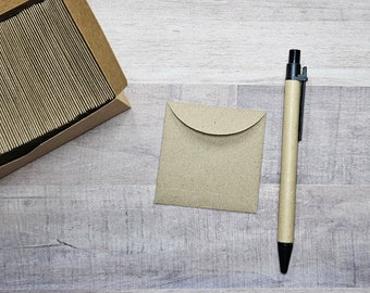 May include: A brown paper envelope with a flap on the top, a black pen, and a box of brown paper envelopes.