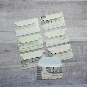 May include: A set of eight vintage-style envelopes with different designs. The envelopes are made of paper and have a cream color. Some of the envelopes have a handwritten message on them. The envelopes are perfect for adding a touch of vintage charm to your correspondence.