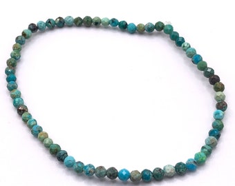May include: A delicate bracelet featuring small, faceted turquoise beads. The beads display a range of blue-green hues, creating a subtle, natural aesthetic. The bracelet is strung together, showcasing a simple yet elegant design, suitable for everyday wear.