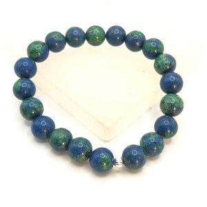 K&ouml;nnte beinhalten: Ein blaues und gr&uuml;nes Edelstein-Armband mit einem silbernen Verschluss. Das Armband besteht aus runden Perlen und ist etwa 18 cm lang.