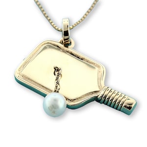 Item 54. Pickleball pendant with pearl ball 14 Kt. yellow gold.