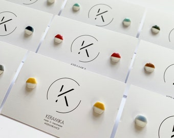 May include: A set of ceramic earrings with a geometric shape and a two-tone color design. The earrings are displayed on white cards with the brand name "KERAMIKA" and the text "made in manchester" and "@KERAMIKAMCR".
