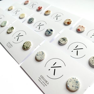 May include: A set of ceramic stud earrings with various speckled patterns. The earrings are displayed on white cards with the brand name "KERAMIKA" and the text "made in manchester @KERAMIKAMCR".