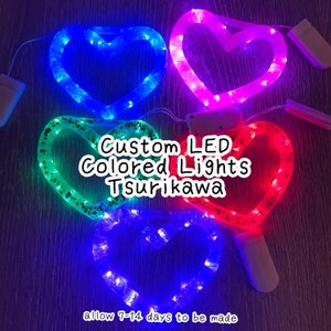 May include: Heart-shaped LED lights in blue, pink, green, and red. The lights are strung around a clear plastic heart frame. Text on the image reads "Custom LED Colored Lights Tsurikawa" and "allow 7-14 days to be made".