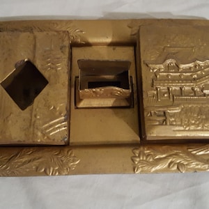 Vassoio decorativo per fumatori a tema asiatico Nikko, in metallo dorato pesante, pre-seconda guerra mondiale, con pavone, scatola per sigarette, posacenere, porta fiammiferi, volpe e gatto