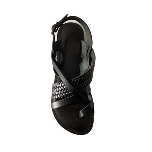 May include: Black leather sandals with a braided strap design. The sandals have a closed toe and an ankle strap.