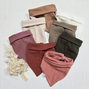 Può includere: Un set di otto bavaglini in mussola di cotone per neonati in vari colori, tra cui marrone, beige, rosa, rosso e verde. I bavaglini sono realizzati in un materiale morbido e assorbente e sono perfetti per mantenere puliti i vestiti del bambino.